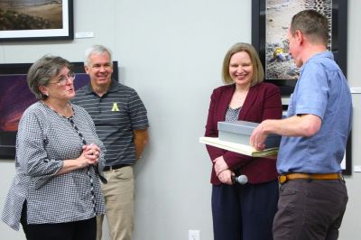 Karen Willis Amspacher, executive director of the Core Sound Museum and Heritage Center in Harkers Island, North Carolina;  Shannon Adams, IT consultant in Morehead City, North Carolina; and Michelle Witt, archivist in Raleigh, receive a box of oral history recordings from Mark Coltraine, oral historian at Appalachian State University in Boone, North Carolina. (Photo by Teri Saylor)