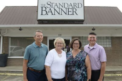 Dale Gentry, Teresa Gentry, Lesli Bales-Sherrod and Jimmy Sherrod pose in front of The Standard Banner the day the Gentrys sold it to the Sherrods. The sale ushers in a new generation of local ownership a year before the newspaper celebrates its 100th anniversary.